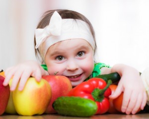 Happy Kid with vegetables and fruits.
